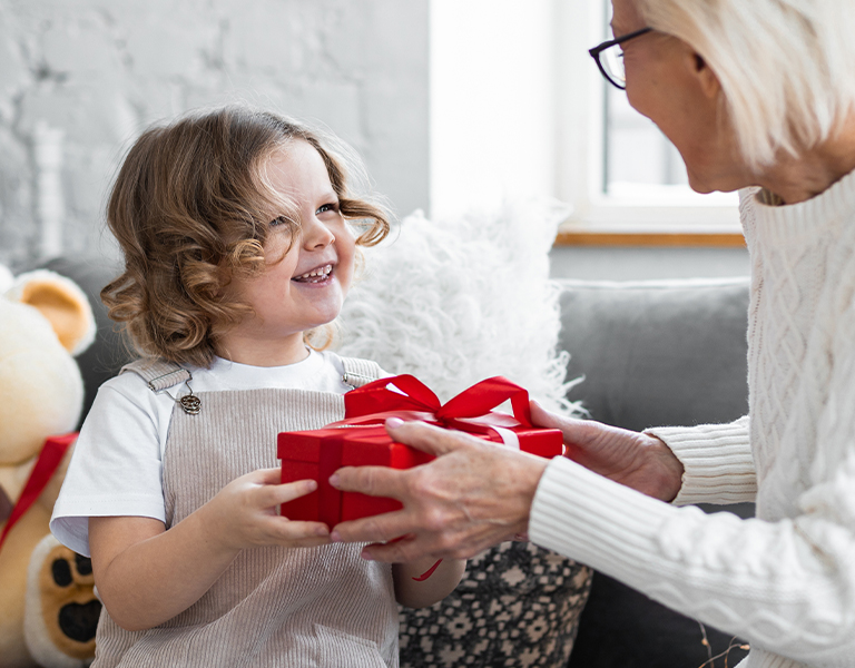 Dívka dává babičce dárek k Vánocům